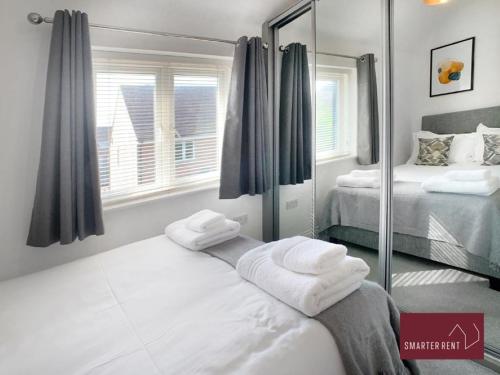 Habitación con 2 camas y espejo. en Jennetts Park, Bracknell - 2 Bedroom Maisonette With Parking, en Bracknell