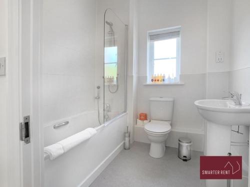 a white bathroom with a toilet and a sink at Jennetts Park, Bracknell - 2 Bedroom Maisonette With Parking in Bracknell