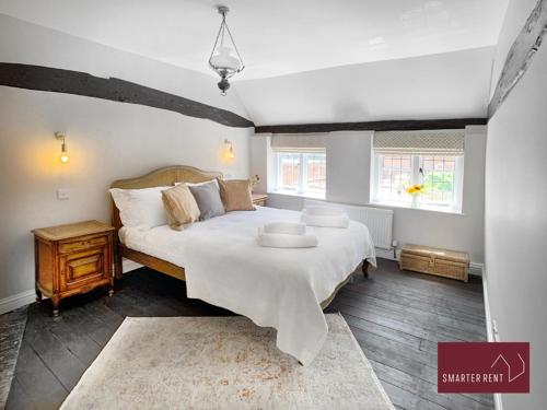 um quarto com uma cama grande e uma mesa. em Henley-On-Thames - 2 Bedroom Cottage With Permit Parking Close By em Henley on Thames