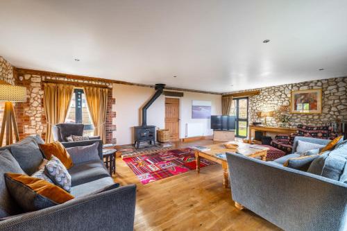 a living room with two couches and a fireplace at Oyster Barn in Titchwell
