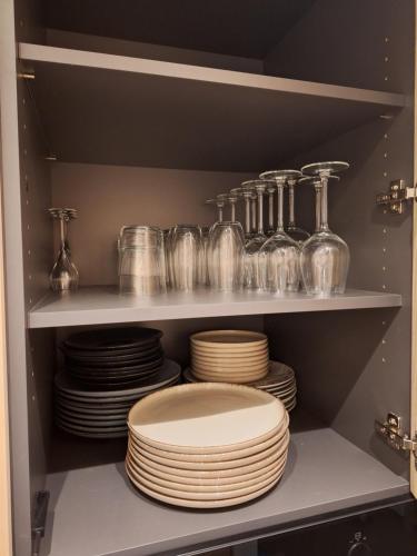 un montón de platos y vasos en un estante en Appartement Wellington D3 Knokke full service et parking en Knokke-Heist