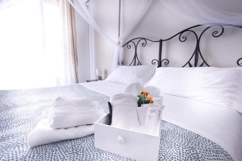 una cama blanca con almohadas blancas y una caja en ella en Porta Amari, en Palermo
