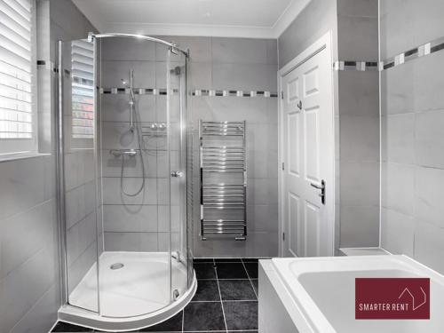 a bathroom with a shower and a sink at Chobham - 3 Bedroom Townhouse With Garden & Parking in Chobham