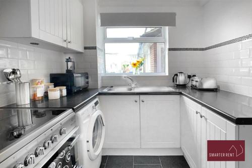 a white kitchen with a sink and a dishwasher at Farnborough - Lovely 1 Bedroom House in Blackwater