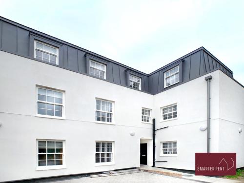 a white building with a black roof at Eton Windsor - 1 Bedroom Flat - With Parking in Eton