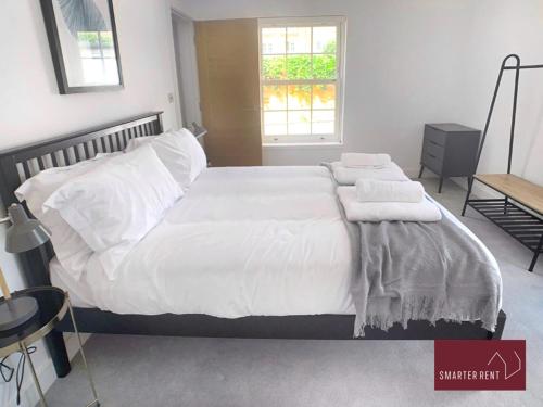 a bedroom with a bed with white sheets and pillows at Eton Windsor - 1 Bedroom Flat - With Parking in Eton