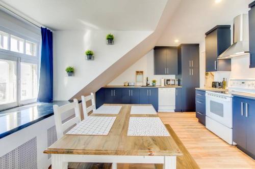 a kitchen with a wooden table and blue cabinets at Maison Grenier - Le Nid in Quebec City
