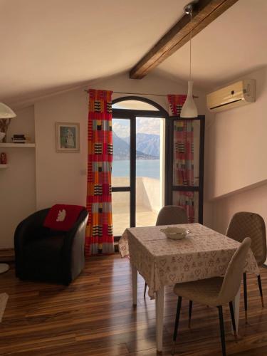 sala de estar con mesa, silla y ventana en Apartment Jovana en Kotor