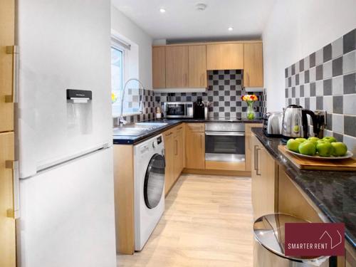 a kitchen with a white refrigerator and a dishwasher at 2 Bed House with Garden, Woking in Chobham