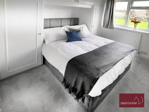 een slaapkamer met een groot bed met een blauw kussen bij Vansittart Road, Windsor in Windsor