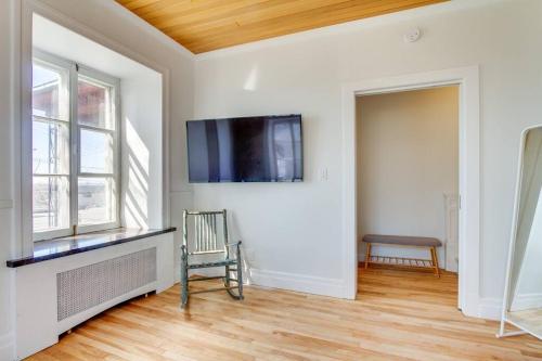 a living room with a flat screen tv on a wall at Maison Grenier - Le Nid in Quebec City