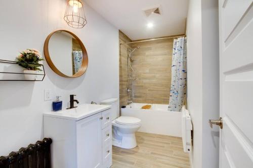 La salle de bains est pourvue de toilettes, d'une baignoire et d'un lavabo. dans l'établissement Maison Grenier - Le Nid, à Québec