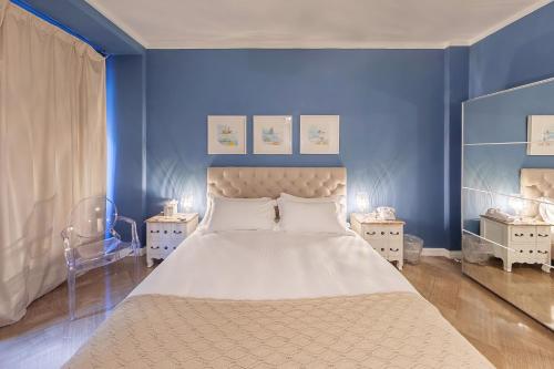 een slaapkamer met een groot bed met blauwe muren bij Maison de Famille in Palermo