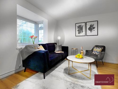 a living room with a blue couch and a table at Wokingham - 2 Bed Modern House - Parking in Wokingham