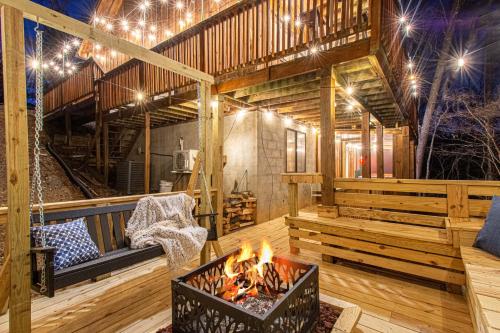 Habitación con chimenea en una terraza con luces en The Family Stone Luxe Cabin Sleeps 12 Hot tub Dogfriendly Dollywood, en Pigeon Forge