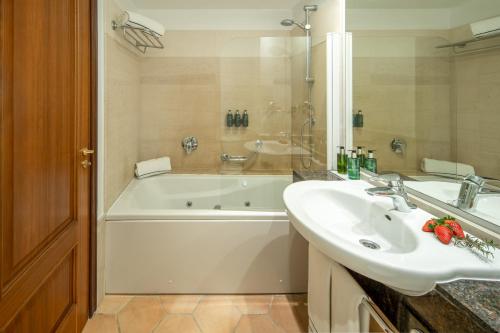 a bathroom with a white tub and a sink at Melia Cala d'Or Boutique Hotel in Cala d´Or