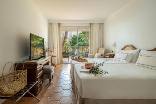 una camera con un grande letto e una televisione di Melia Cala d'Or Boutique Hotel a Cala d´Or