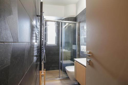 a bathroom with a toilet and a glass shower at The Urban Utopia at Glyfada in Athens