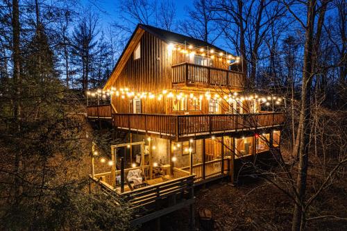 a tree house with lights on the side of it at The Family Stone Luxe Cabin Sleeps 12 Hot tub Dogfriendly Dollywood in Pigeon Forge