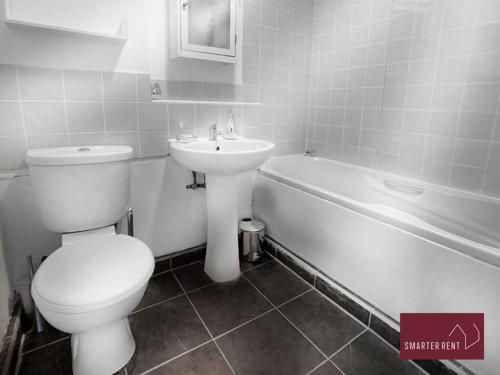 a bathroom with a toilet and a sink and a tub at Hitchin - Millstream - 2 Bedroom Coach House in Ickleford