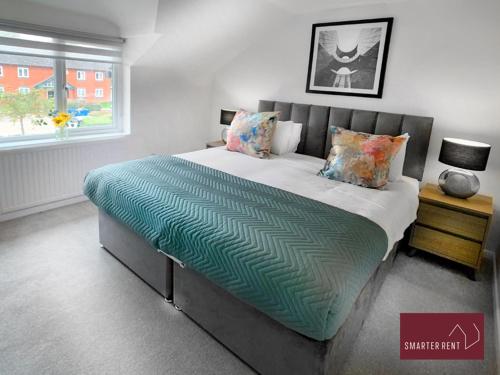 a large bed in a bedroom with a window at Farnborough - Peel Court - 2 Bed Parking & Garden in Cove