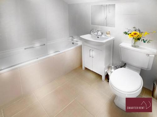 a bathroom with a toilet and a sink and a tub at Farnborough - Peel Court - 2 Bed Parking & Garden in Cove