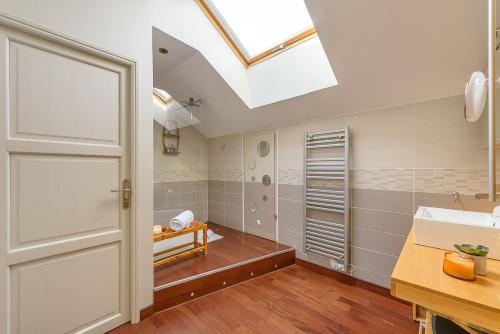 een badkamer met een dakraam en een wastafel bij La Villa suspendue, Jolie terrasse vue lac au calme - LLA Selections by Location lac Annecy in Saint-Jorioz