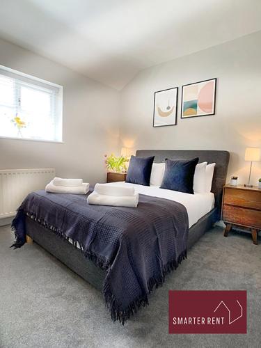 a bedroom with a large bed with blue pillows at Ascot - Parking Garden Pets Welcome in Ascot