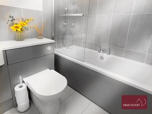 La salle de bains est pourvue de toilettes blanches et d'une baignoire. dans l'établissement Wokingham - 2 Bedroom Ground Floor Flat - With Parking, à Wokingham