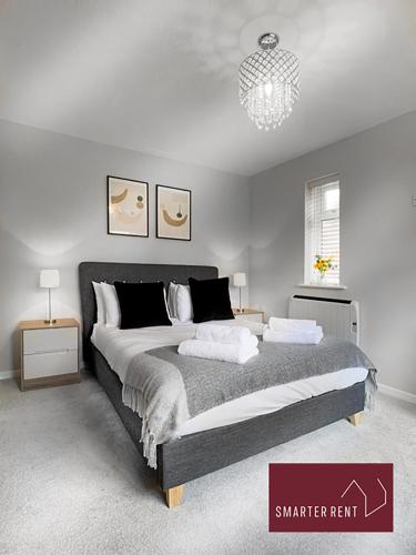 a bedroom with a large bed and a chandelier at Lightwater - 1 Bedroom House - With Parking in Bagshot