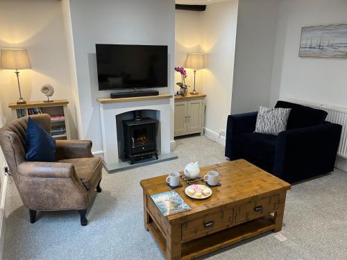 カウズにあるThe Sail Loft, Cowes High Streetの暖炉とテレビのあるリビングルーム