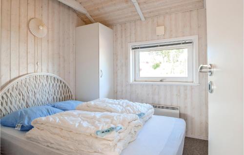 ein Schlafzimmer mit einem Bett mit einer Bettdecke und einem Fenster in der Unterkunft Amazing Home In Bjert With Wifi in Binderup Strand