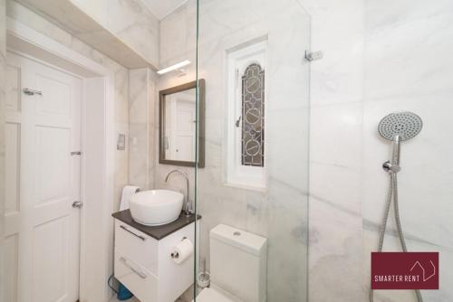 a bathroom with a toilet and a sink and a shower at The Gazebo in London