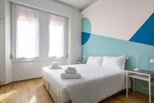 una camera con un letto bianco e una parete blu di Affittacamere Biscotti22 a Bologna