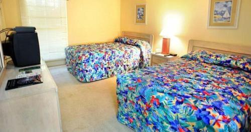 ein Schlafzimmer mit 2 Betten und einem TV in der Unterkunft Litchfield Beach & Golf Resort in Pawleys Island