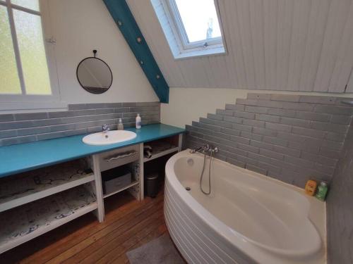 une salle de bain avec une baignoire et un lavabo dans l'établissement Maison 8 personnes, quartier Benoit, 300m plage, à La Baule