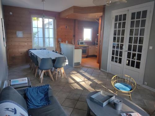 un salon avec une table et des chaises et une cuisine dans l'établissement Maison 8 personnes, quartier Benoit, 300m plage, à La Baule