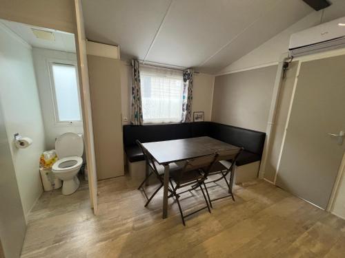 une petite salle de bains avec une table et des toilettes. dans l'établissement Mobil home 6 personnes, à Saint-Cyprien