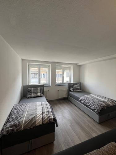 2 Betten in einem Zimmer mit 2 Fenstern in der Unterkunft City Unterkunft 4 in Heilbronn