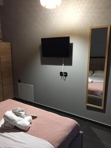 a room with a bed and a mirror and a tv at V&M Traditional Luxury Villa in Tolo