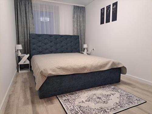 una camera con un grande letto e un tappeto di Jaukūs apartamentai centre A. J. Greimo g. a Šiauliai