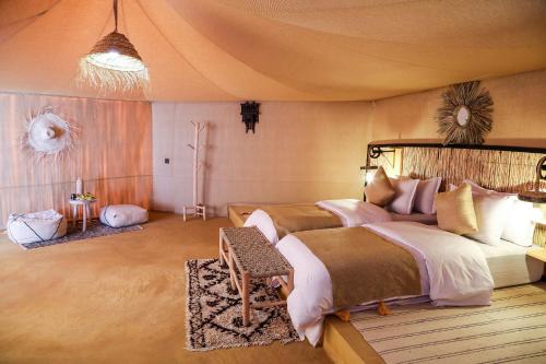 a bedroom with a large bed in a tent at Celia Desert Camp in Merzouga