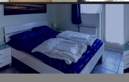 ein unverpacktes Bett mit blauer Bettwäsche in einem Schlafzimmer in der Unterkunft Oesterbaai 6 in Wemeldinge