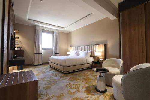 um quarto de hotel com uma cama e uma cadeira em فندق لارتشي تبوك Larichy Tabuk em Tabuk