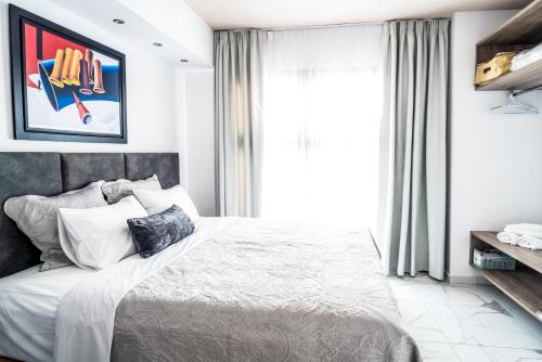 a bedroom with a bed and a window at Sea & the City in Thessaloniki