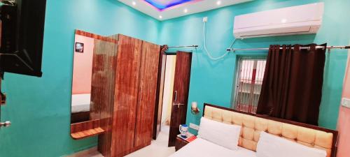 a blue room with a bed and a mirror at Hotel Ananya Inn in Varanasi