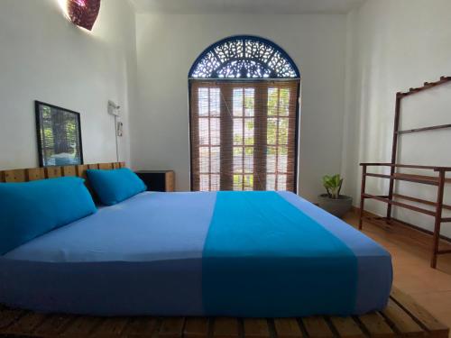 a bedroom with a blue bed and a window at Seconds Hostel - Colombo in Colombo