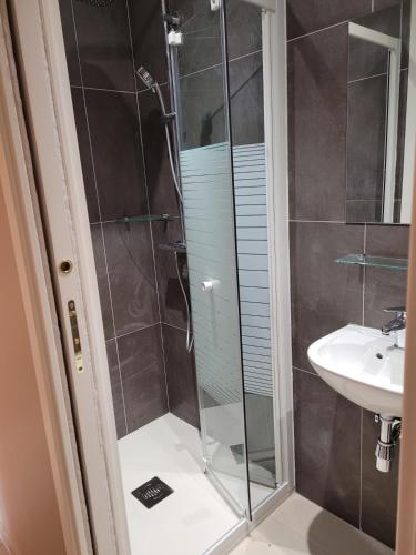 une douche avec une porte vitrée à côté d'un lavabo dans l'établissement APARTMENT VILLA ABOVE MONACO, à La Turbie