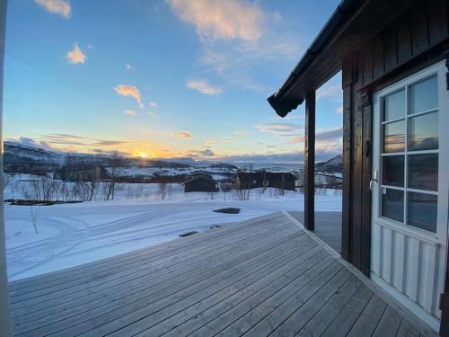 Aussicht von der Terrasse eines Hauses im Schnee in der Unterkunft Hytte i Neverfjord. in Kvalsund
