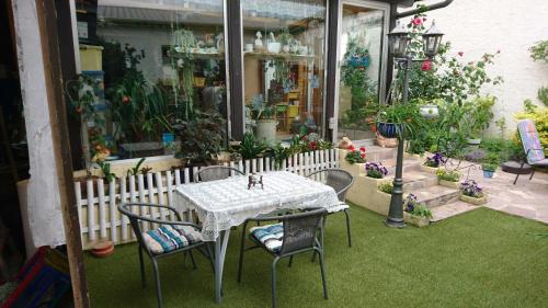 a table and chairs in a garden with plants at Ferienwohnung Käfer in Rust